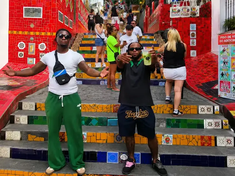 Two friends standing on the colorful Selarón Steps in Rio
